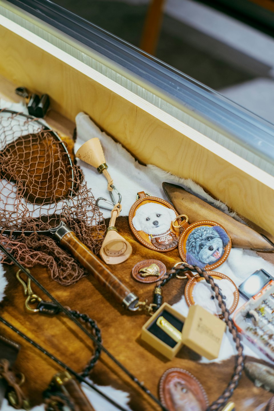 Artesanía en cuero y accesorios de pesca en un estante de tienda.